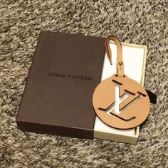 the louis vuitton keychain is in its box and it has a tag attached to it