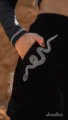 a woman is holding onto her pants with a snake on it