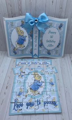 a birthday card with a blue bow on it and a puzzle in the shape of a rabbit