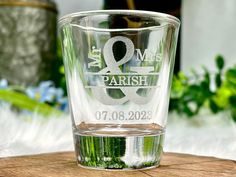 a shot glass with the words mr and mrs on it sitting on top of a wooden table