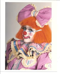 a clown with orange hair and pink makeup