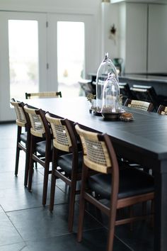 a dining room table with chairs and a glass clochet on it's top