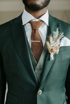 a man in a suit and tie with a boutonniere on his lapel