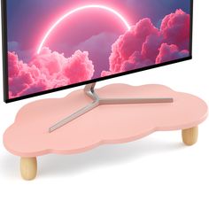 a flat screen tv sitting on top of a pink flower shaped table with wooden legs