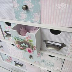 an assortment of drawers with flowers and birds in the nest on them, all painted pink and blue