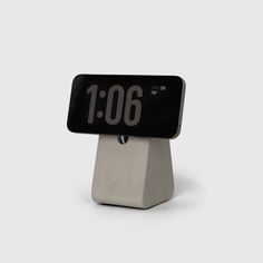 an alarm clock with the time displayed on it's display stand in front of a white background