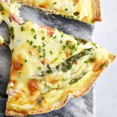 there is a piece of pizza with cheese and asparagus on the top slice