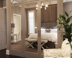 a bedroom with mirrored closet doors and furniture