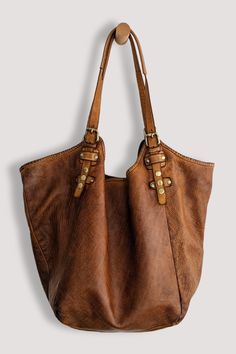 Elevate your hobo style with our exquisite Soft and Slouchy Hobo in Stone Washed "Cognac On the Rocks". The luxurious design features a magnetic closure and a spacious interior, while the vintage brass snap and buckle details add a unique, edgy touch. Its comfortable extra long shoulder straps and thoughtful large center zip section make it both chic and practical. Embrace the rebel within and make a statement with this genuine piece of art and truly rebellious companion. Each bag is a unique, h Leather Artist, Hobo Style, Leather Finish, On The Rocks, Luxurious Design, Best Bags, Raw Gemstones, Tote Backpack, New Bag