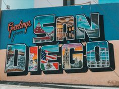 the san diego sign painted on the side of a building with images of different cities