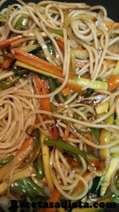 stir fried noodles with vegetables and sauce in a wok