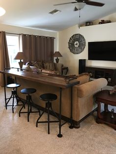 a living room filled with furniture and a flat screen tv mounted to the side of a wall