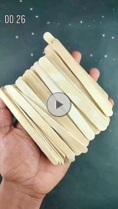 a hand holding a stack of wooden skewers