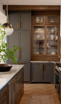 a kitchen with gray cabinets and wooden floors