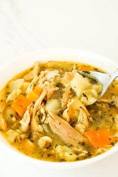 a white bowl filled with chicken and vegetable soup