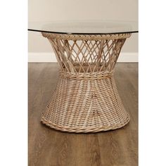 a wicker table with glass top on wooden floor