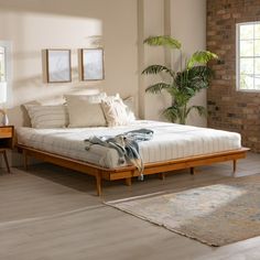 a large bed sitting next to a brick wall in a room with wooden flooring