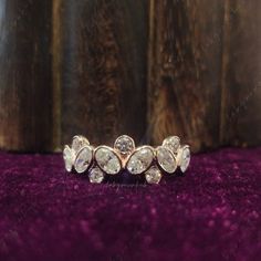 a close up view of a diamond ring on a purple velvet surface with wood in the background