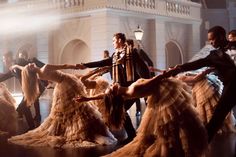 a group of people dancing on top of a wooden floor