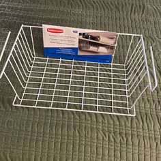 a bed with a metal basket on top of it and a card in the middle