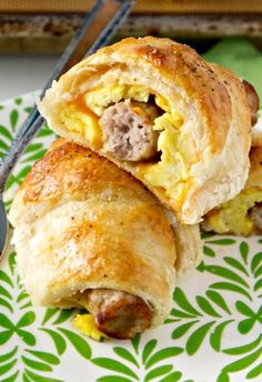 sausage egg and cheese breakfast roll ups on a green floral plate with a fork next to it