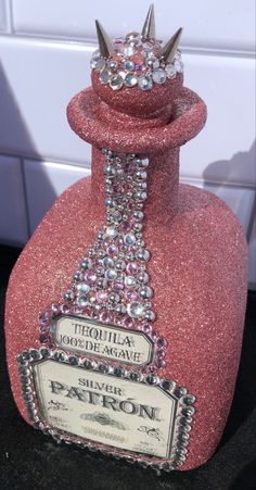 a pink bottle with a crown on top