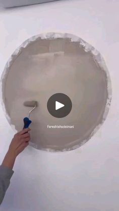 a person painting a ceiling with white paint and a blue sprayer in the middle