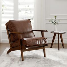 a brown leather chair sitting on top of a white rug next to a small table