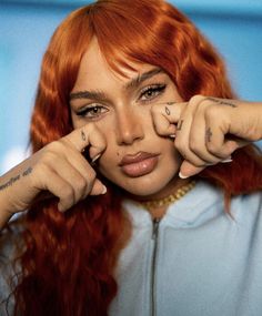 a close up of a person with red hair and piercings on her fingers,