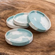 three blue and white plates sitting on top of a wooden table next to each other