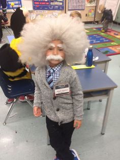 a young boy wearing a wig and tie with a fake moustache on his face