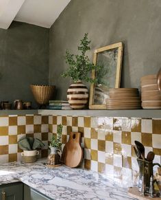 a kitchen counter topped with lots of pots and pans on top of it's shelves