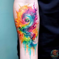 a colorful tattoo on the arm with watercolor paint splatters and swirls