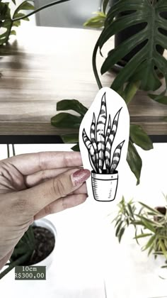 a person holding up a paper cut out of a houseplant