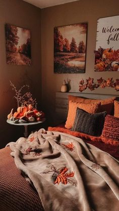 a bedroom with two paintings on the wall and a bed covered in an orange blanket