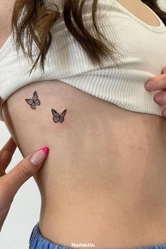 a woman's stomach with two butterflies on her left side, and the lower part of