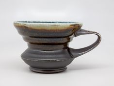 a brown and white cup sitting on top of a table