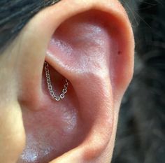 a close up of a person's ear with a chain on it