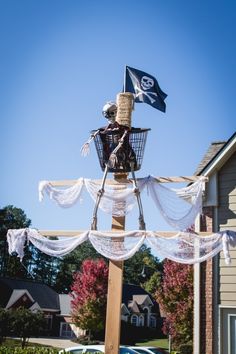 a scarecrow on top of a wooden pole with a flag in the back ground