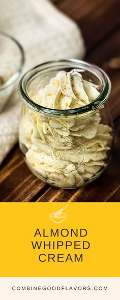 a glass jar filled with whipped cream on top of a wooden table