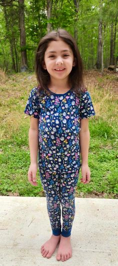 This two piece pajama set features a navy blue background with spring florals and playful gray kittens. Earth-friendly, hypoallergenic bamboo viscose extra gentle on sensitive and eczema-prone skin. Breathable bamboo fabric adjusts to keep children snuggly and warm in winter, and cool and comfortable in summer. No snaps, buttons, or interior tags to rub or cause irritation. Short-sleeved shirt and matching pull on pants. Designed in coordinating prints and colors for sibling matching. Extra stre Casual Blue Floral Print Sleepwear, Blue Short Sleeve Matching Sleepwear Set, Blue Floral Print Short Sleeve Sleepwear, Casual Floral Print Tops For Sleepover, Playful Fitted Short Sleeve Sleepwear, Playful Blue Sleepwear For Spring, Blue Printed Tops For Pajama Party, Relaxed Fit Floral Print Top For Bedtime, Floral Print Short Sleeve Sleep Top