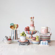 a table topped with plates and bowls filled with fruit on top of a white surface