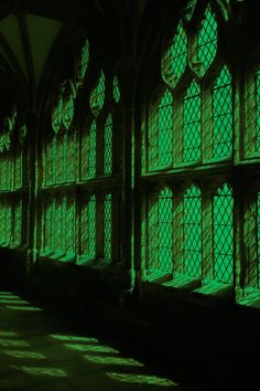 an old building with many windows and green light coming through the window sills