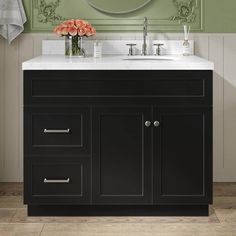 a bathroom vanity with a mirror above it and flowers in the vase on the counter