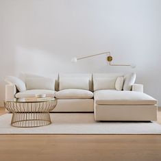 a white couch sitting on top of a hard wood floor next to a coffee table