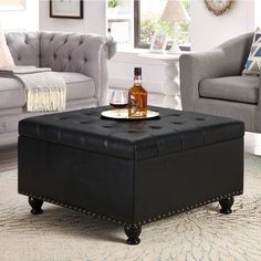 a black ottoman with a bottle of alcohol on it