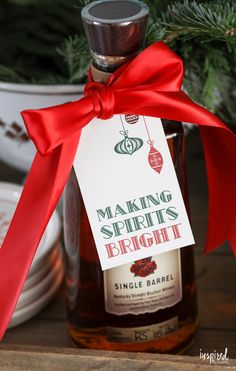 a bottle of alcohol with a red ribbon around it and a tag that says making spirits bright