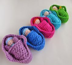 four crocheted baby shoes lined up on a white surface