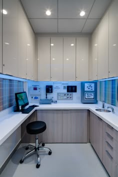 an office cubicle with desk, chair and computer on the counter top in front of it