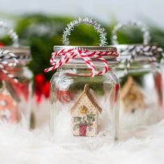 three glass jars filled with christmas decorations and candy canes